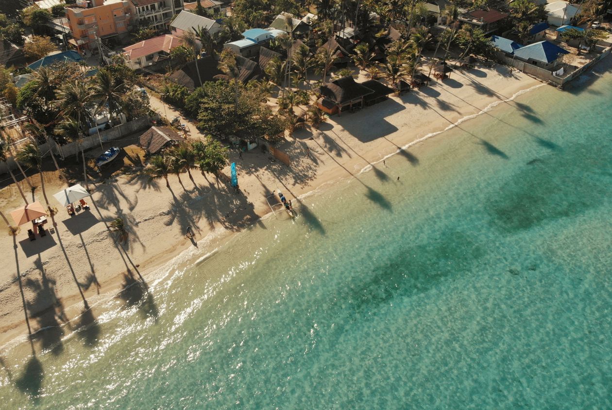 Aerial view of a palm-shaded white sand beach and turquoise water at Santa Fe, Bantayan Island