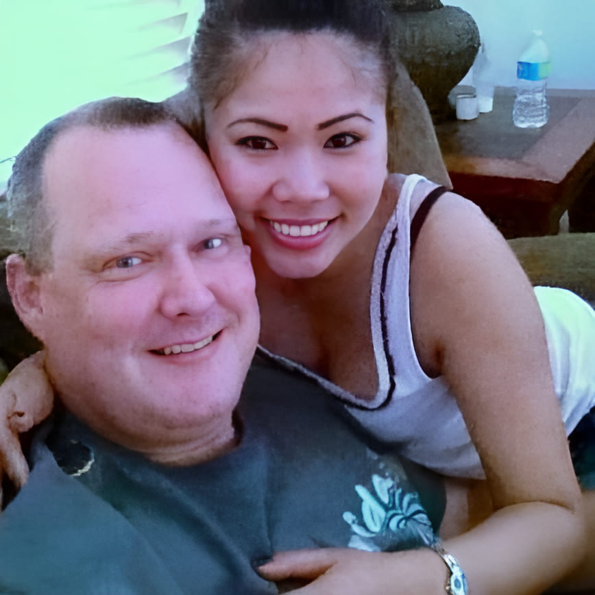 Steve and Cirila smiling close together, with Cirila leaning over his shoulder
