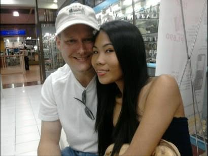 Steve in a white cap and Cirila smiling together in a shopping mall.