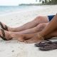 A white sand beach with a couple showing only their legs on a white sand beach in the Philippines.